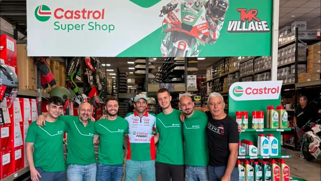 Foto di gruppo sotto l’insegna Castrol Super Shop al TMR Village